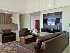 a living room with a couch and a tv at Hotel Jequitibá in Gurupi