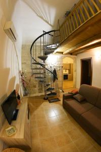 a living room with a spiral staircase and a couch at L'insula in Scicli