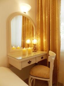 a bedroom with a dressing table with candles and a mirror at Skiathos Driades in Koukounaries