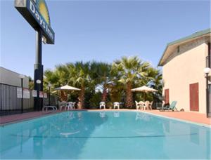 a large swimming pool with chairs and umbrellas at Days Inn by Wyndham Yuba City in Yuba City