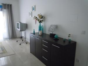a dresser with a vase of flowers in a room at Farmer Fraguas in Rio Maior