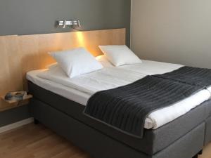 uma cama com duas almofadas num quarto em Linköpings Cityhotell och Vandrarhem em Linköping
