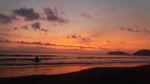 a person walking into the ocean at sunset at Casajungla Hostel in Jacó