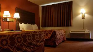 a hotel room with a bed and a window at American Inn Of Liberal in Liberal