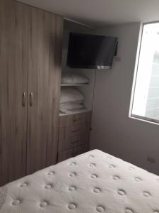 1 dormitorio con 1 cama, armario y TV en Departamento Acogedor en los Portales de Cayma, en Arequipa