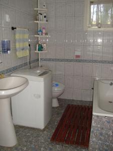 a white bathroom with a sink and a toilet at Padurea De Argint in Văratec