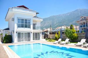 a villa with a swimming pool in front of a house at Villa Belvedere in Fethiye