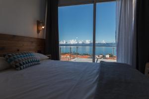 a bedroom with a bed and a large window at Blue Planet São Jorge Azores - RRAL nº 1341 in Velas