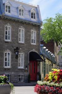 a house with a red door on a street at Hôtel Marie-Rollet in Quebec City