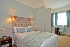 sypialnia z dużym łóżkiem i biurkiem w obiekcie Maples House Hotel w Dublinie