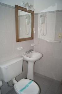 a bathroom with a toilet and a sink and a mirror at La Posada de los Robles in Las Grutas