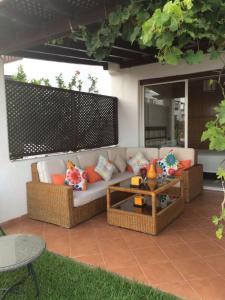 a white couch with pillows on a patio at Cabobeach Appartement in Cabo Negro