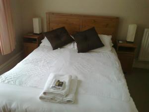 Una cama blanca con toallas y una bandeja. en Kingsley Hotel, en Bournemouth