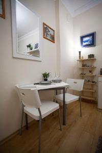een eettafel met witte stoelen en een spiegel bij Apartment Charlie PERFECT PRICE in Belgrado