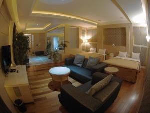 uma sala de estar com um sofá e uma cama em ChangSing Business Motel em Tainan