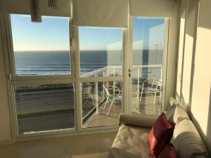 a room with a balcony with a view of the ocean at Marco Polo Platinum Apartamento in Mar del Plata