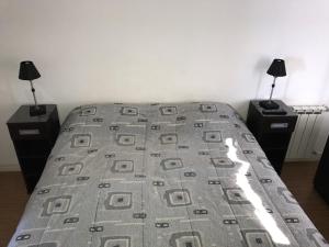 ein Bett in einem Schlafzimmer mit zwei Tischen und zwei Lampen in der Unterkunft Marco Polo Platinum Apartamento in Mar del Plata