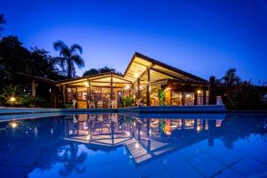 ein Haus mit Swimmingpool bei Nacht in der Unterkunft Pousada Caminho do Rei in Praia do Rosa