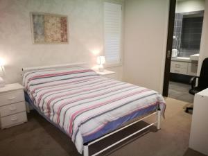 庫克角的住宿－幸運旅館，一间卧室配有带条纹毯子的床
