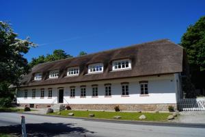 um grande edifício branco com um telhado castanho em Fuglsø Kro Bed & Breakfast em Knebel