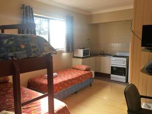 a small room with a bunk bed and a kitchen at Snowgate Motel + Apartments in Berridale