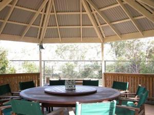 a large wooden table and chairs in a patio at Smoky Cape Retreat in South West Rocks