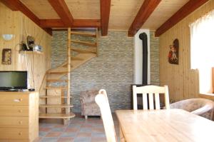 a living room with a wooden staircase and a table at Rekreační chata Karasín in Karasín