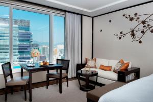 a bedroom with a bed and a table and a couch at The Peninsula Hong Kong in Hong Kong