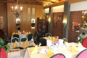 a dining room with tables and chairs and a chandelier at Hotel Palla in Essen