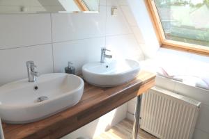 Un baño con dos lavabos y una ventana. en TM Apart Hotel Essen, en Essen