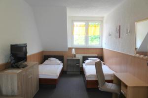 a hotel room with two beds and a television at Hotel Palla in Essen