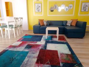 uma sala de estar com um sofá azul e uma mesa em Fundeni Apartments em Bucareste