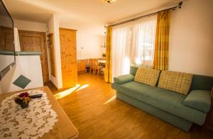 a living room with a green couch and a table at Flachauer Bergkristall in Flachau