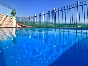 a swimming pool with a fence and blue water at Wellness Suite Na' Canuna' in Roddi
