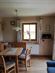 a dining room with a table and chairs and a window at Appartement Pilzhof in Filzmoos