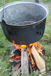 una olla en un palo en el fuego del campamento en La Mosu, en Porumbacu de Sus