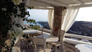 two tables and chairs on a balcony with a view at Milo Milo Suites in Mandrakia