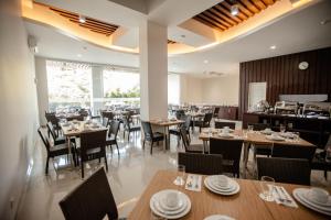 a dining room with tables and chairs and a restaurant at Whiz Prime Hotel Sudirman Makassar in Makassar