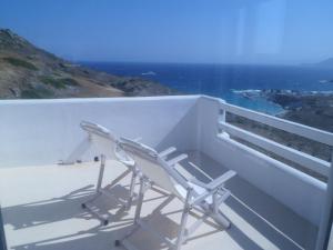 a white chair sitting on the ledge of a balcony at Milo Milo Suites in Mandrakia