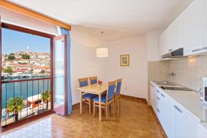 een keuken met een tafel en uitzicht op de oceaan bij Maistra Select Riva Apartments in Vrsar