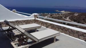 a white bench sitting on top of a stone wall at Milo Milo Suites in Mandrakia