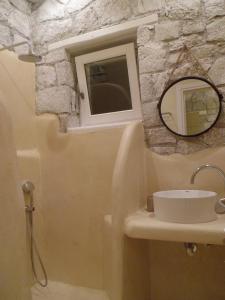 a bathroom with a sink and a window and a mirror at Milo Milo Suites in Mandrakia