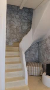 a staircase in a room with a stone wall at Milo Milo Suites in Mandrakia