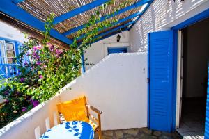 a patio with a blue door and a table and chairs at Hotel Landeris in Katapola