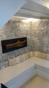 a stone wall with a couch in a room at Milo Milo Suites in Mandrakia