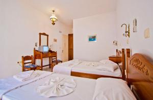 a hotel room with two beds and a television at Hotel Landeris in Katapola