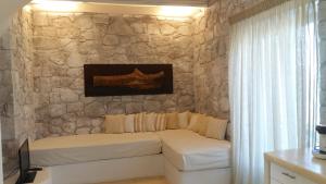 a bedroom with two beds against a stone wall at Milo Milo Suites in Mandrakia