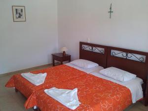 a bedroom with two beds and a cross on the wall at Agnanti Apartments in Vathi