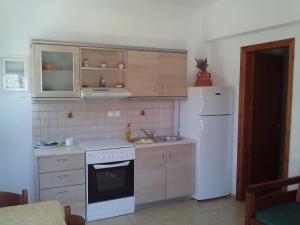 uma cozinha com um fogão branco e um frigorífico em Agnanti Apartments em Vathi