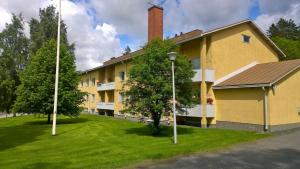 um edifício amarelo com uma chaminé ao lado em Jokioinen-Forssa apartment 48m2 em Jokioinen